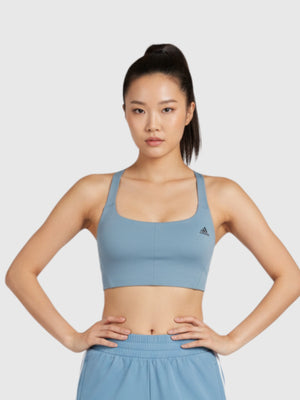 Model mengenakan Adidas CoreFlow Medium-Support Bra berwarna biru muda dengan desain strappy back dari FTFO || BIG BRAND LOW PRICE