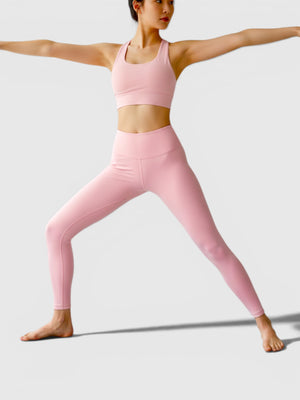 Seorang wanita melakukan pose yoga mengenakan set legging dan bra olahraga Adidas berwarna merah muda lembut dari FTFO || BIG BRAND LOW PRICE