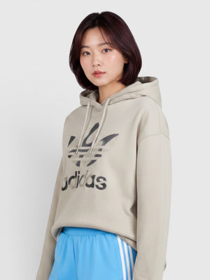 Model mengenakan hoodie beige Adidas x Marimekko dengan logo grafis dan celana pendek biru dari FTFO || BIG BRAND LOW PRICE
