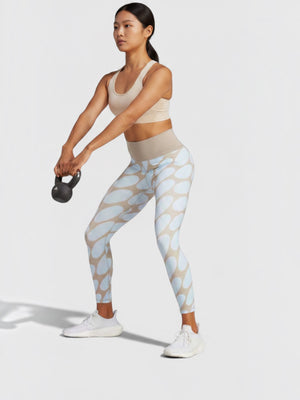 Wanita mengenakan celana ketat Adidas x Marimekko 7/8 bermotif oval biru dengan teknologi AEROREADY dari FTFO || BIG BRAND LOW PRICE