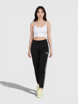Wanita mengenakan Adidas Slim Cuffed Pants hitam dengan tiga garis ikonik dan ujung kaki berusuk dari FTFO || BIG BRAND LOW PRICE