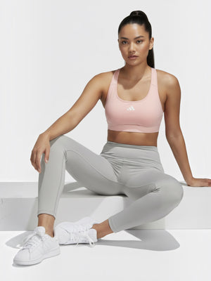 Model mengenakan bra olahraga Adidas Powerreact berwarna merah muda dengan desain racerback dan legging abu-abu dari FTFO || BIG BRAND LOW PRICE