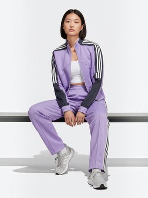 Model mengenakan jaket Adidas Tiro Suit-Up Advanced berwarna ungu dengan aksen tiga garis hitam dari FTFO || BIG BRAND LOW PRICE