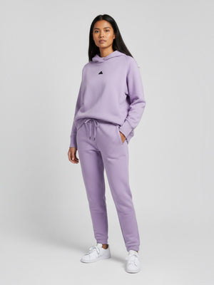 Model wanita mengenakan setelan hoodie dan celana jogger Adidas Z.N.E. berwarna ungu muda dari FTFO || BIG BRAND LOW PRICE