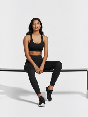 Model mengenakan celana ketat olahraga hitam FTFO || BIG BRAND LOW PRICE dengan detail perforasi dan pinggang tinggi