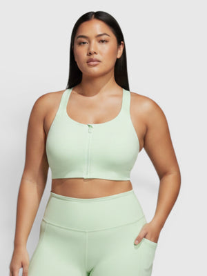 Model wearing FTFO || BIG BRAND LOW PRICE Adidas high-support mint green zip-front sports bra and matching shorts.