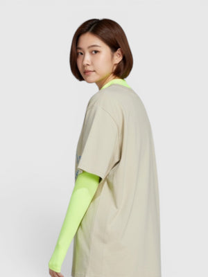 FTFO || BIG BRAND LOW PRICE oversized beige organic cotton t-shirt worn by a woman with neon sleeves and blue shorts