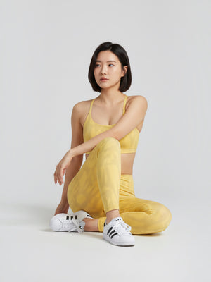 Model wanita mengenakan set sport bra dan legging kuning bermotif dari FTFO || BIG BRAND LOW PRICE untuk yoga