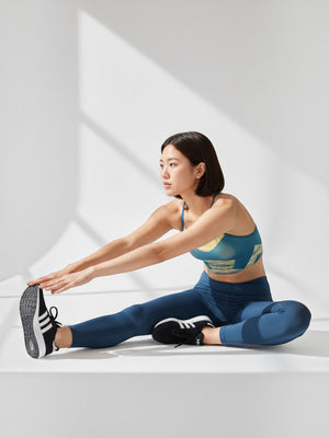 Wanita melakukan peregangan yoga mengenakan sports bra FTFO || BIG BRAND LOW PRICE seamless biru dengan detail kuning