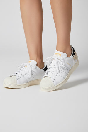 SUPERSTAR W (SUPERSTAR) Adidas Superstar W adalah sepatu legendaris yang tetap menjadi favorit pecinta streetwear sejak