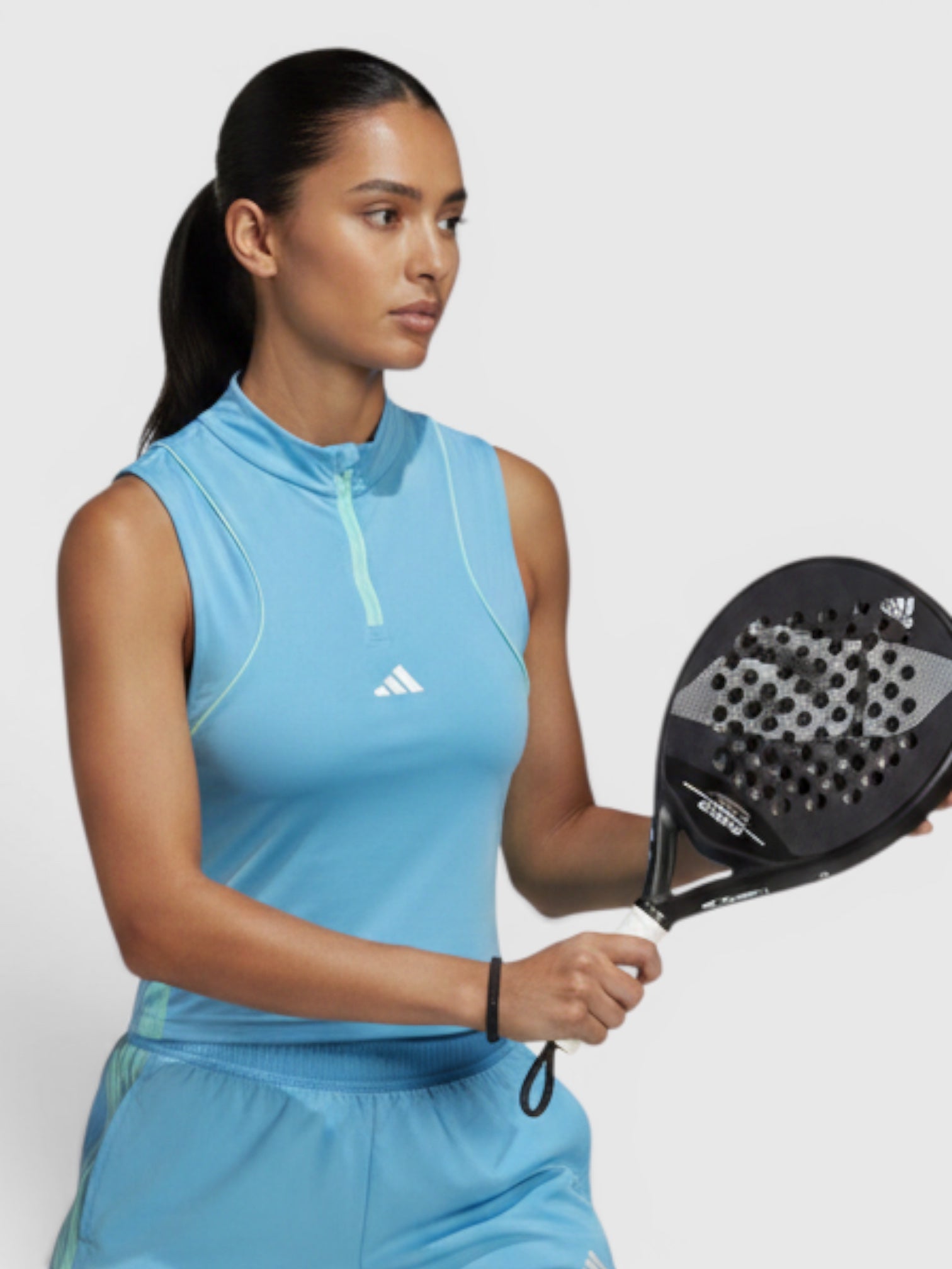 FTFO || BIG BRAND LOW PRICE model wearing a light blue Adidas sleeveless training top and matching shorts holding a padel racket