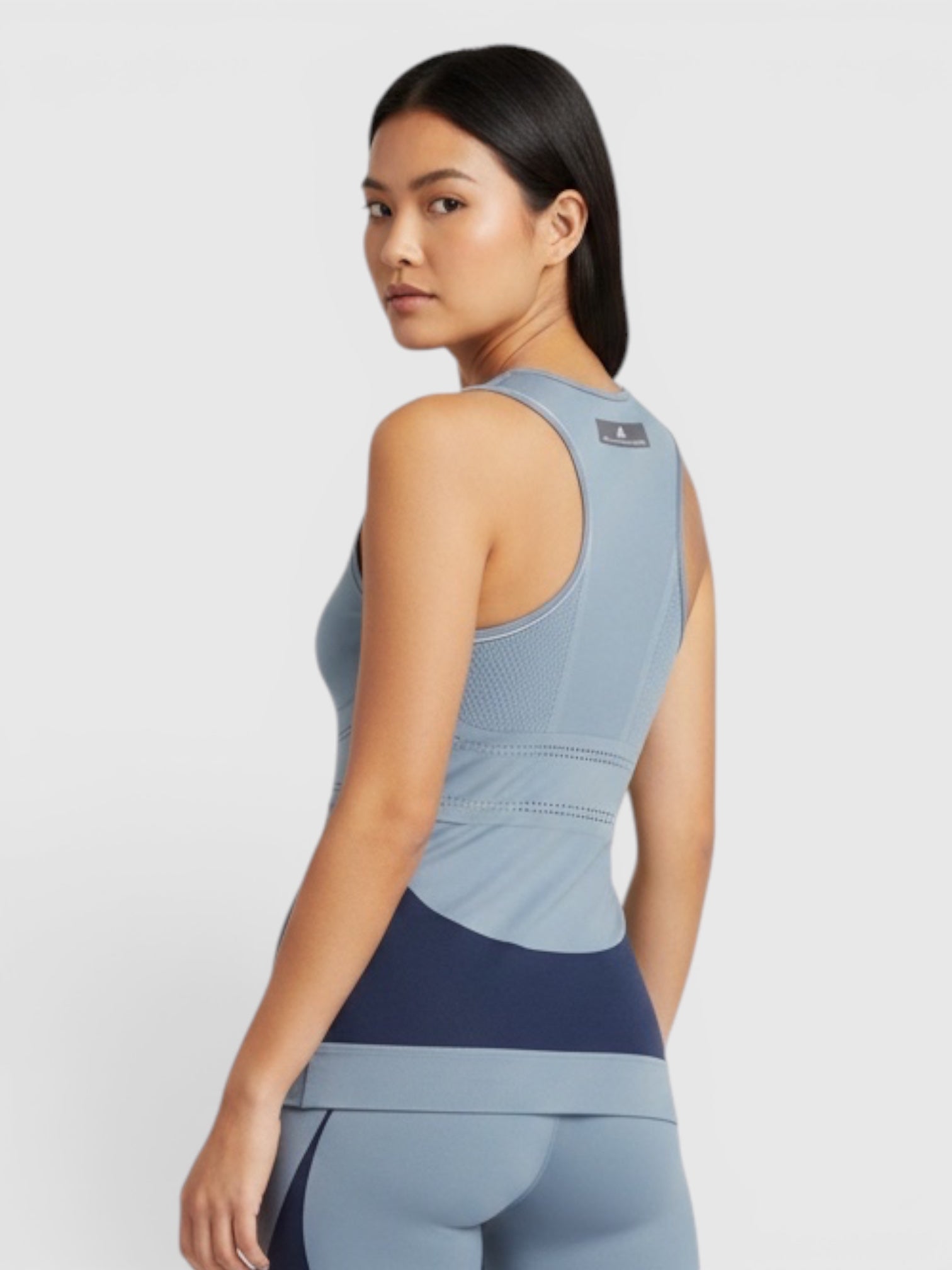 FTFO || BIG BRAND LOW PRICE Adidas Fitsense+ racerback tank top in blue with navy accents worn by a model