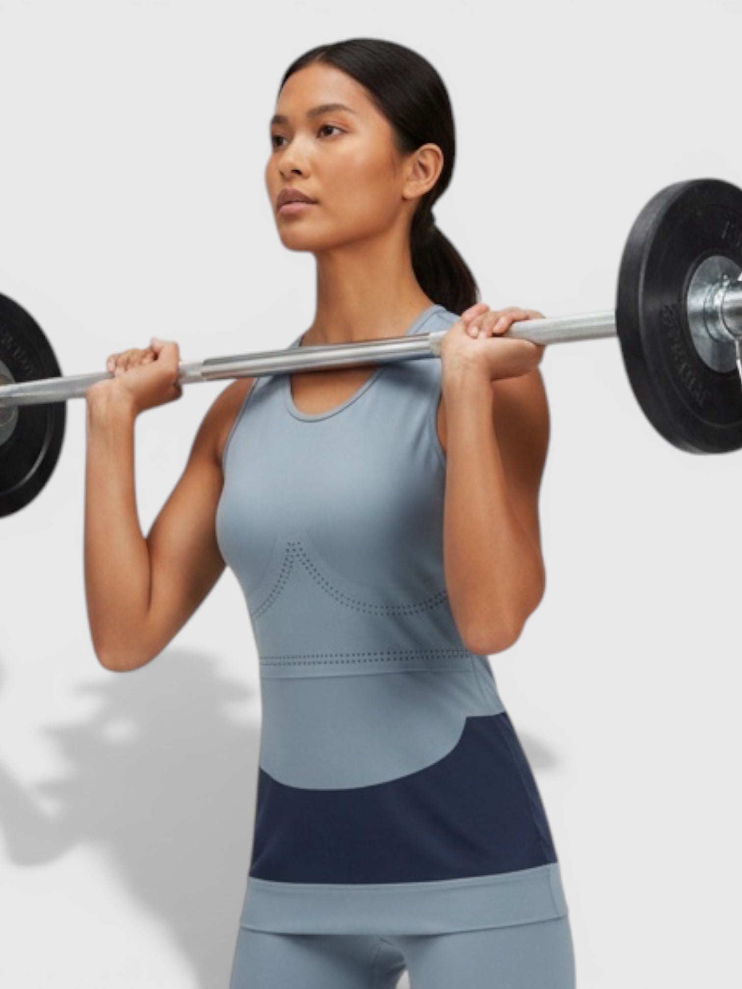 FTFO || BIG BRAND LOW PRICE Adidas Fitsense+ tank top in light blue with navy accents worn by a woman lifting a barbell
