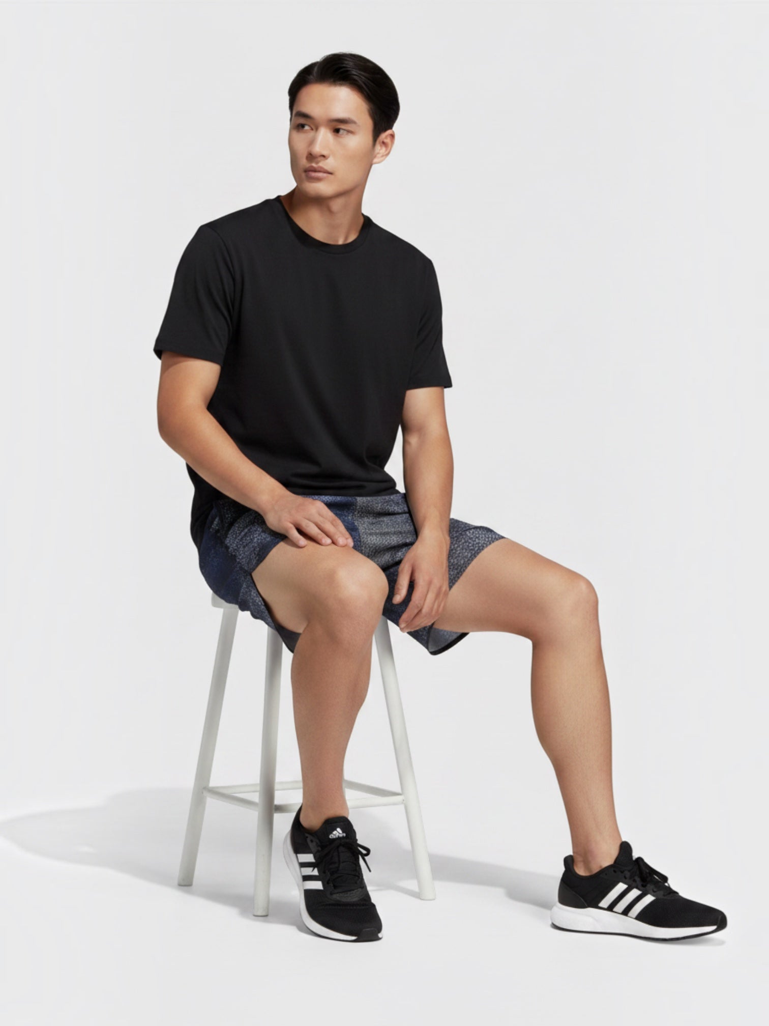 FTFO || BIG BRAND LOW PRICE Adidas B HIIT training shorts in blue patterned fabric worn by a man sitting on a stool