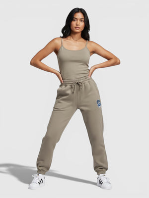 Model wanita mengenakan Adidas Holiday Sweat Pants berwarna khaki dengan detail bordir Trefoil dari FTFO || BIG BRAND LOW PRICE