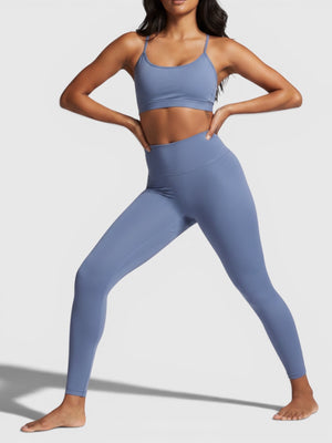 Model mengenakan set olahraga Adidas All Me 7/8 dari FTFO || BIG BRAND LOW PRICE, legging high-rise biru lembut.