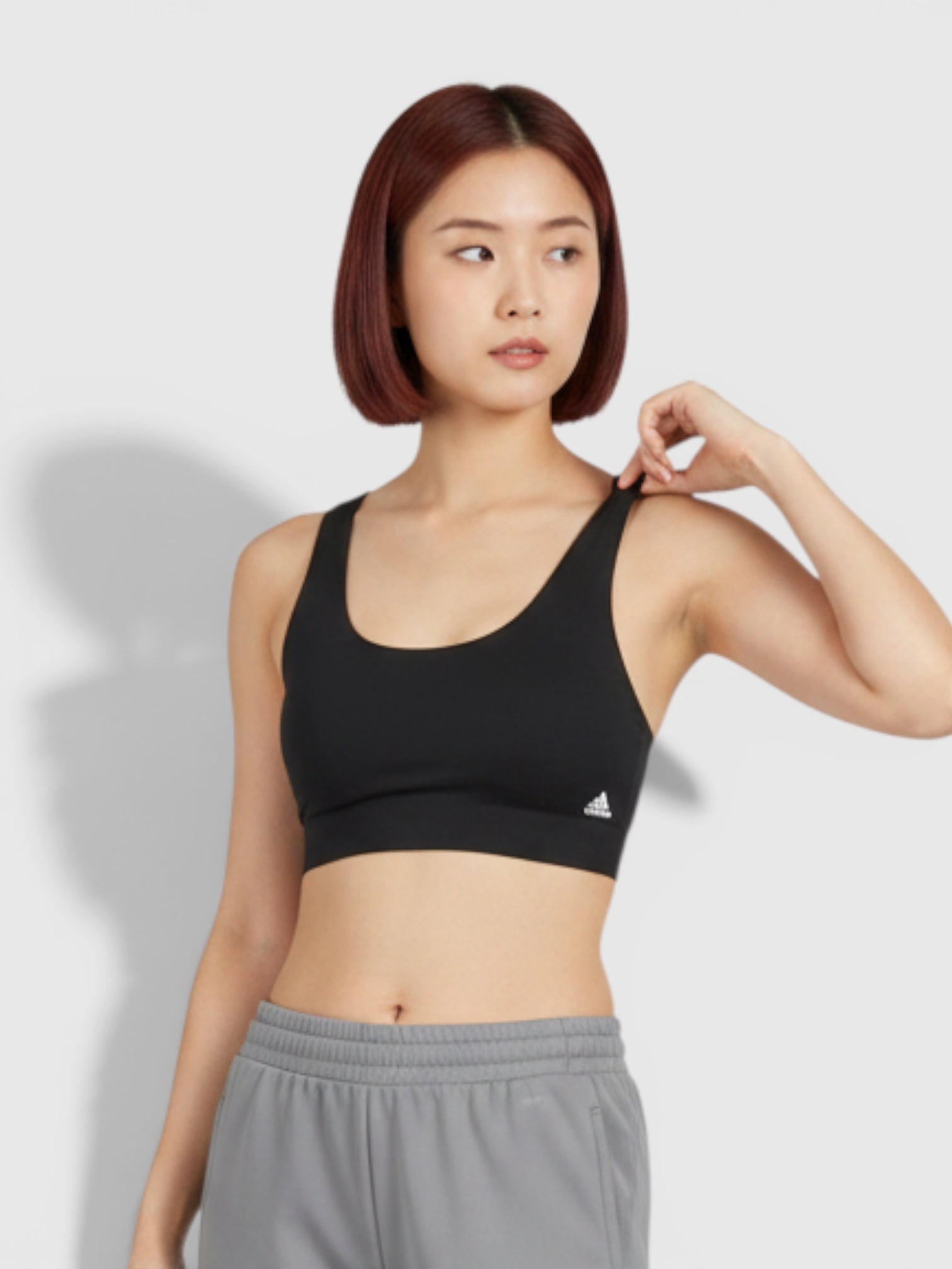 Model wanita mengenakan Adidas Purel LS Bra hitam dan celana jogger abu-abu dari FTFO || BIG BRAND LOW PRICE