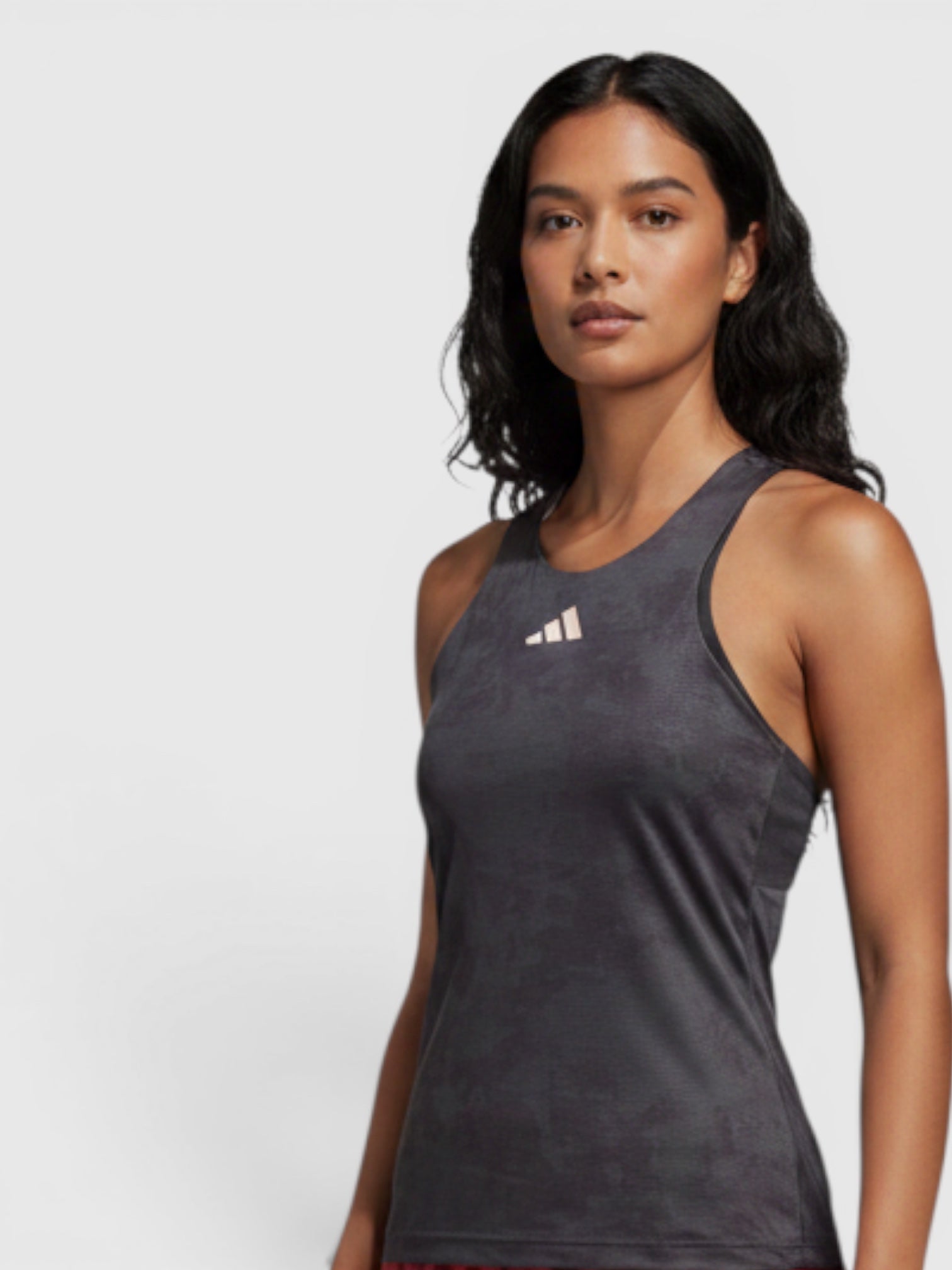 FTFO || BIG BRAND LOW PRICE model wearing a grey Adidas HEAT.RDY tennis Y-tank top with red patterned athletic pants.