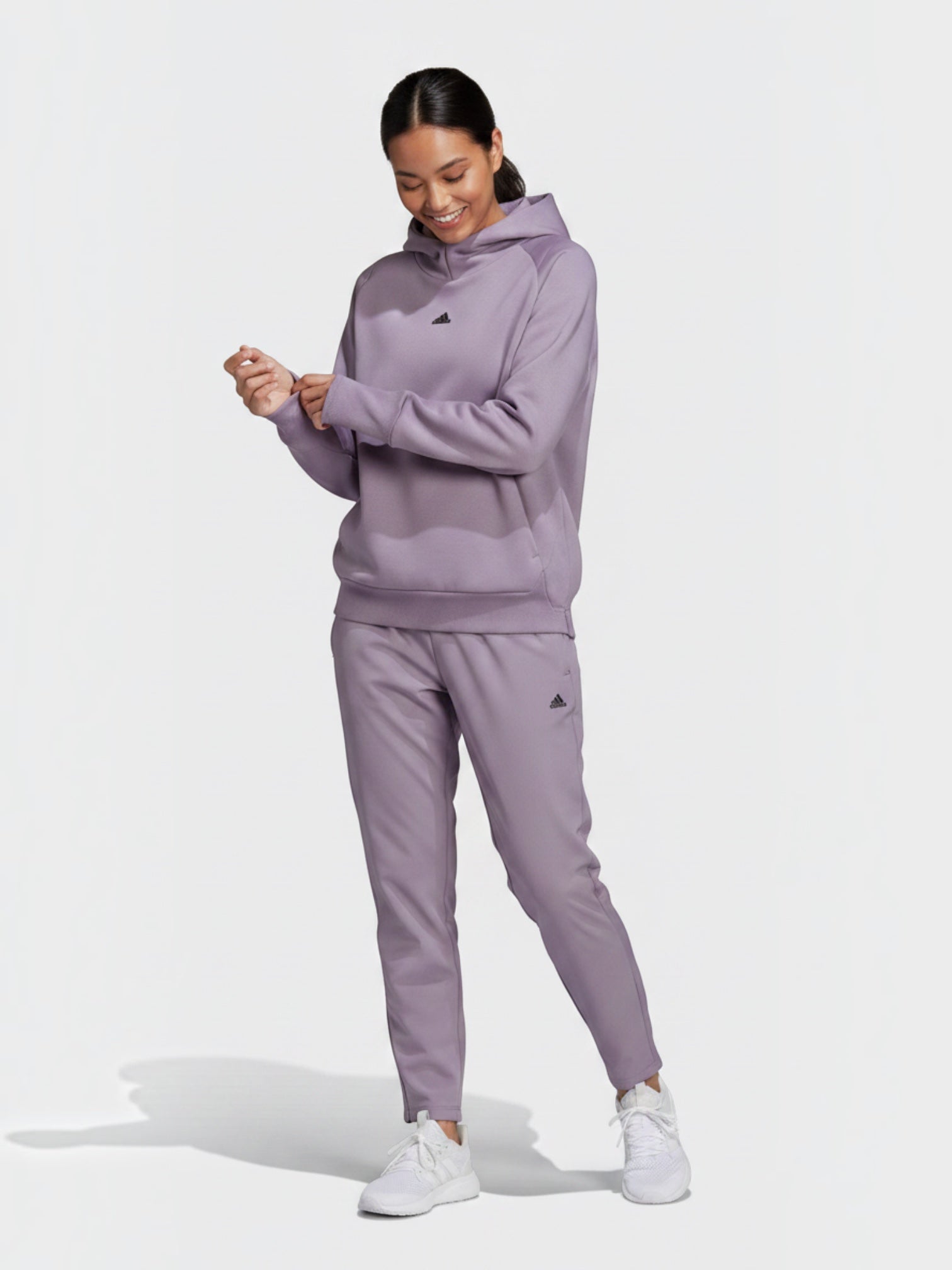 Model wanita mengenakan setelan hoodie dan celana panjang Adidas W Z.N.E. berwarna ungu muda dari FTFO || BIG BRAND LOW PRICE