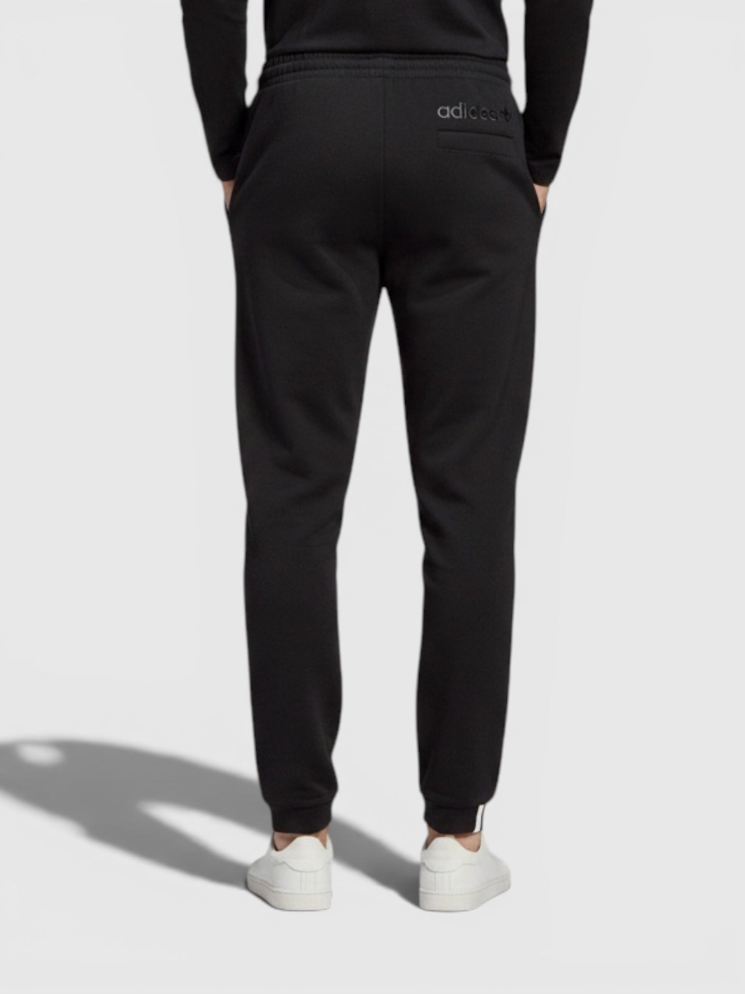 Pria mengenakan celana jogger hitam Adidas dari FTFO || BIG BRAND LOW PRICE dengan potongan regular dan manset elastis