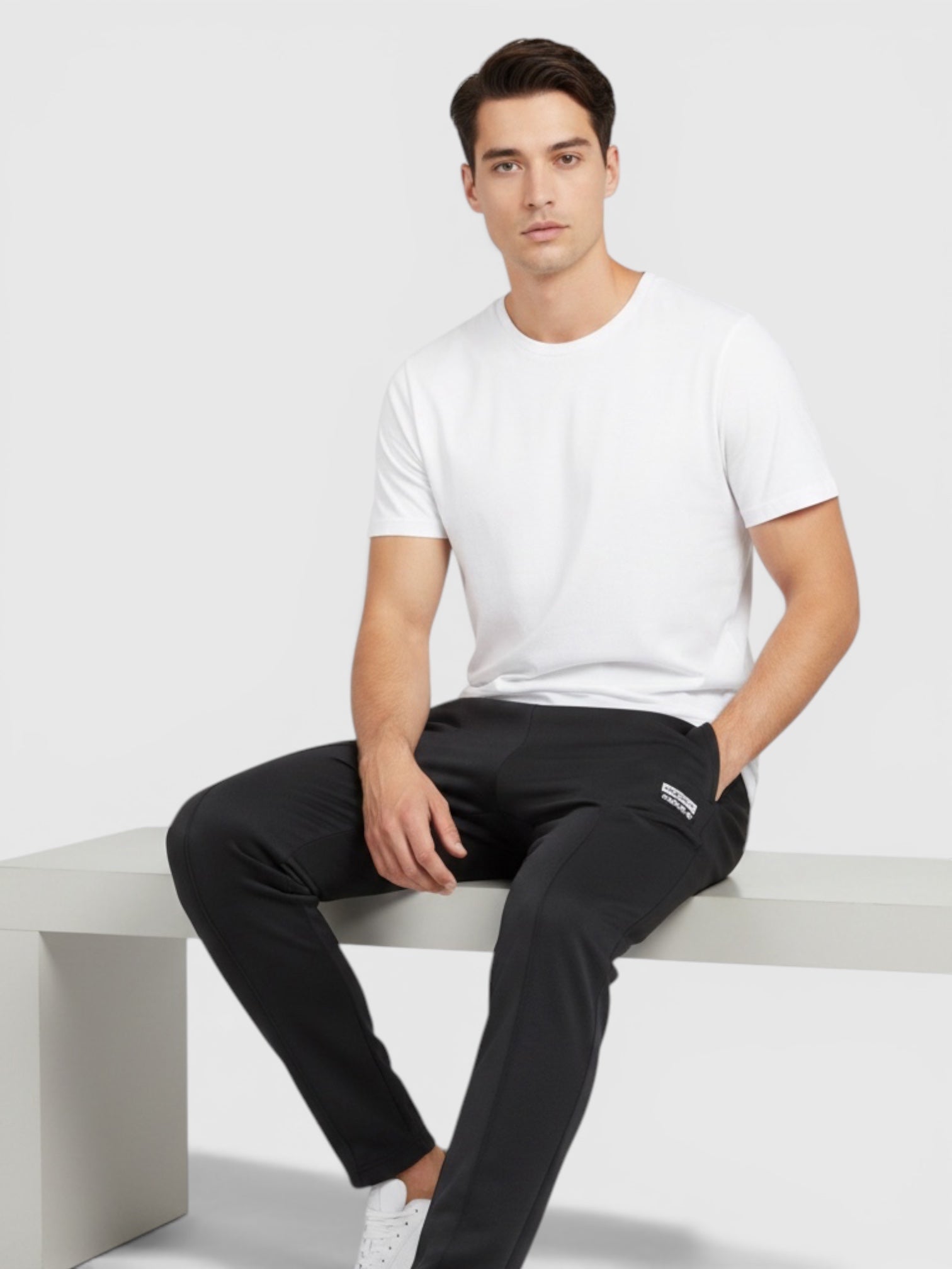 Pria mengenakan celana jogger hitam Adidas dari FTFO || BIG BRAND LOW PRICE dengan kaos putih dan sepatu kets