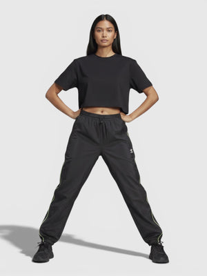 Model mengenakan celana parasut Adidas hitam dengan detail garis neon dari FTFO || BIG BRAND LOW PRICE