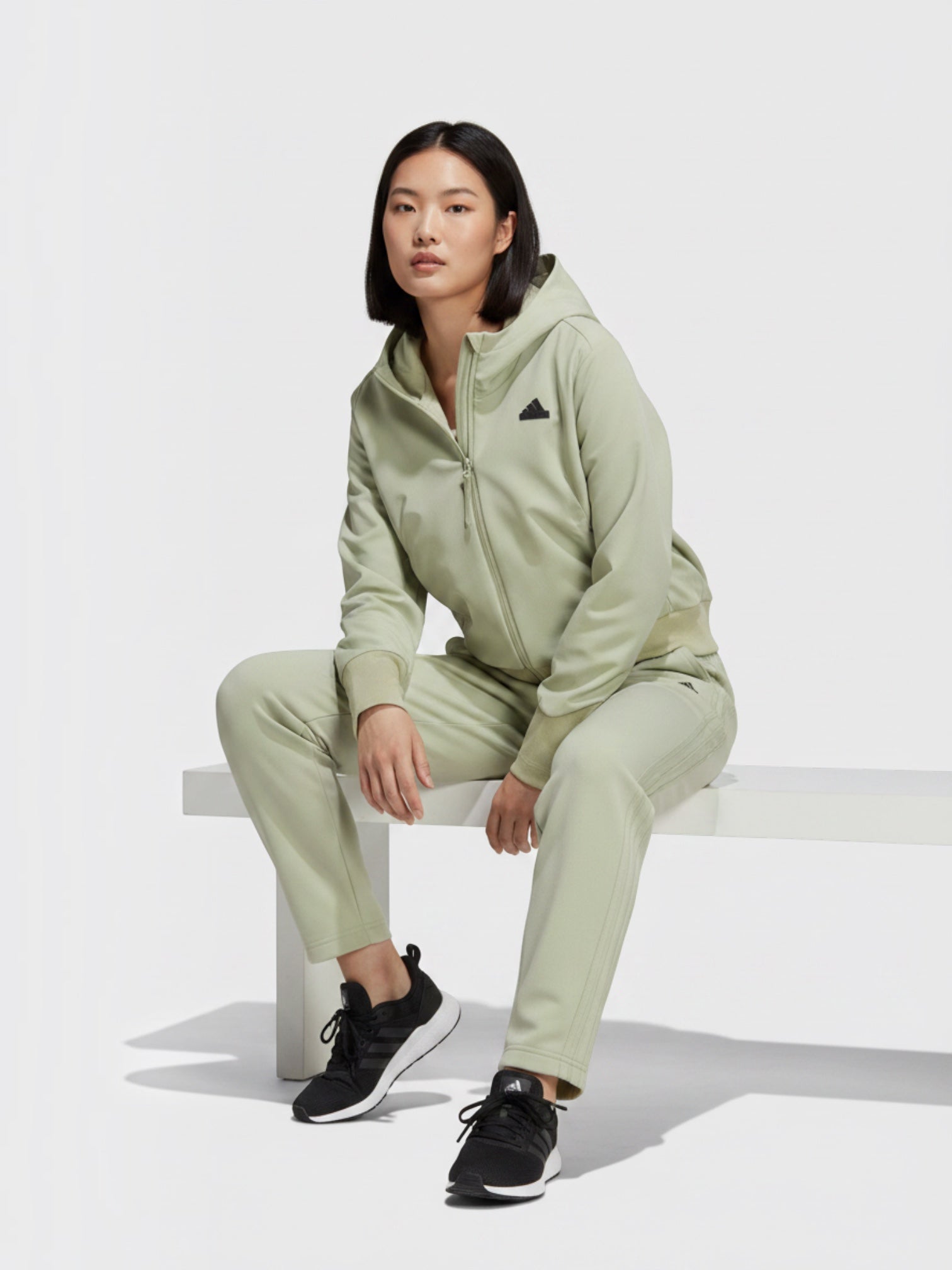 Model wanita mengenakan jaket hoodie Adidas Z.N.E. Woven Full-Zip berwarna hijau sage dari FTFO || BIG BRAND LOW PRICE