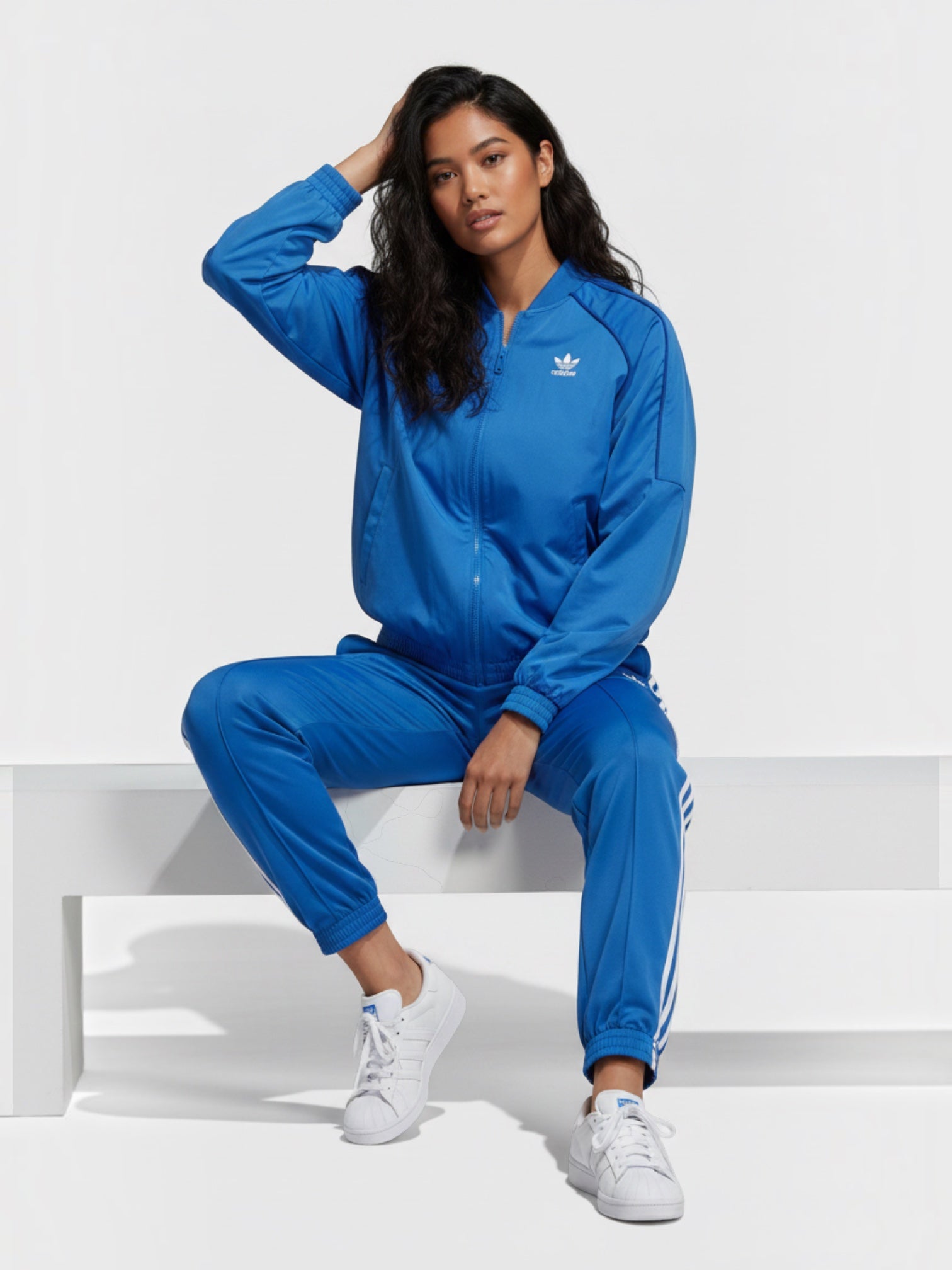 Model wanita mengenakan Adidas Originals FR Track Top biru dengan detail 3-Stripes putih dari FTFO || BIG BRAND LOW PRICE