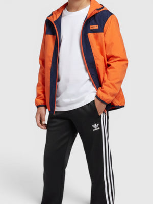 Anak laki-laki mengenakan jaket windbreaker Adidas oranye dan biru dari FTFO || BIG BRAND LOW PRICE dengan celana hitam