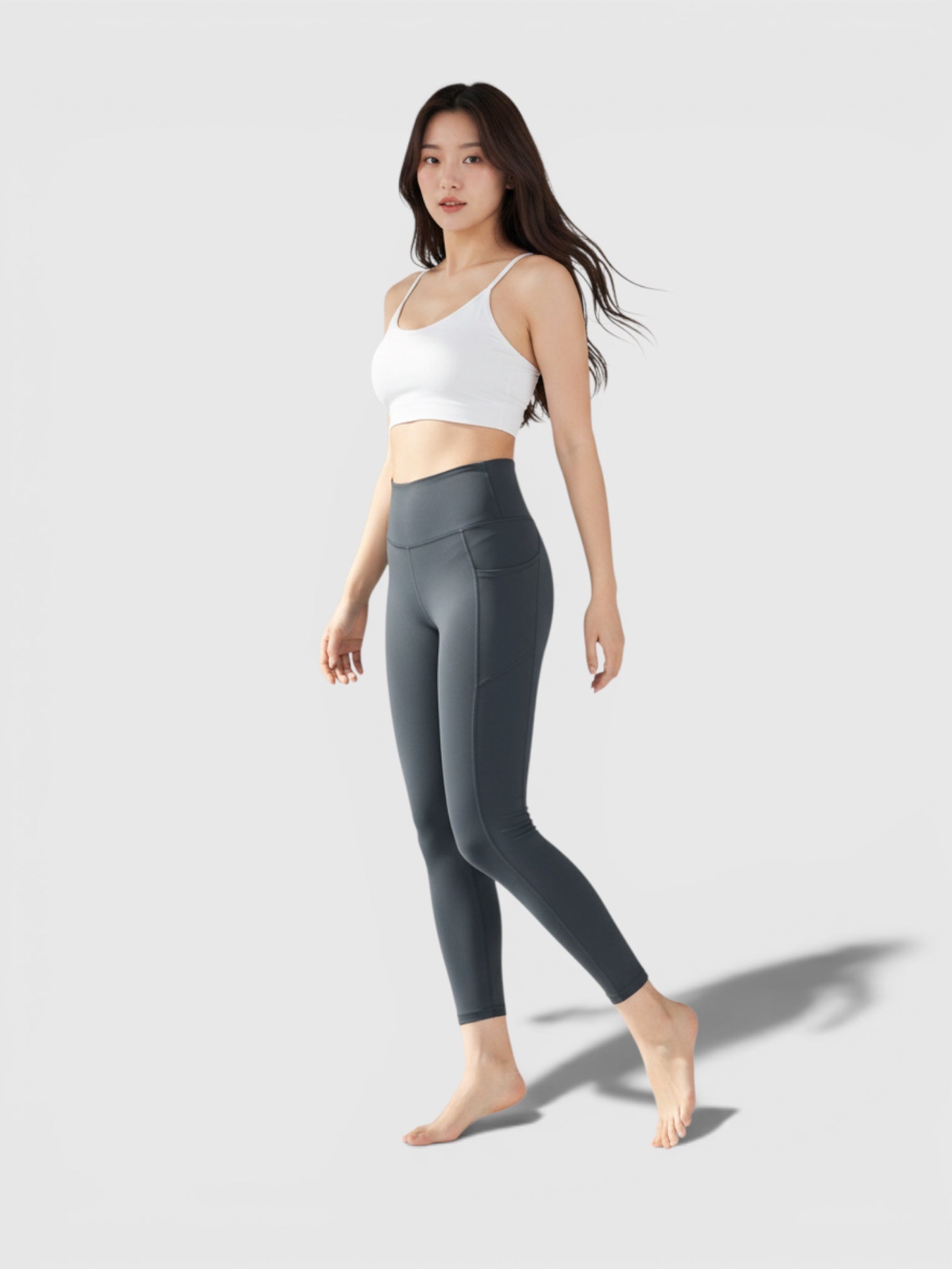 Model mengenakan legging yoga 7/8 FTFO || BIG BRAND LOW PRICE berwarna abu-abu gelap dengan high-rise waist yang elastis.