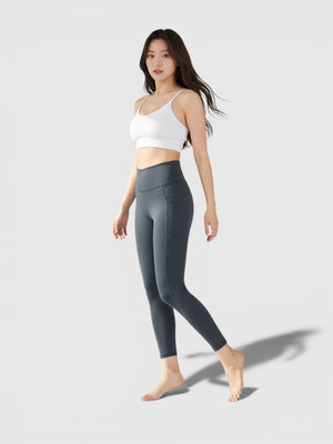 Model mengenakan legging yoga 7/8 FTFO || BIG BRAND LOW PRICE berwarna abu-abu gelap dengan high-rise waist yang elastis.