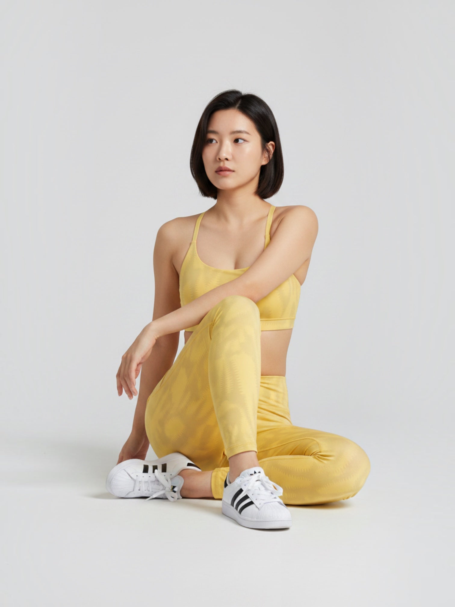Model wanita mengenakan set sport bra dan legging kuning bermotif dari FTFO || BIG BRAND LOW PRICE untuk yoga