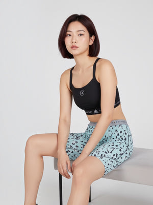 Model mengenakan sport bra hitam FTFO || BIG BRAND LOW PRICE dengan logo adidas by Stella McCartney dan celana pendek