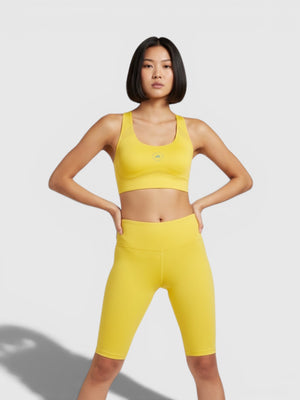 Model mengenakan set olahraga kuning FTFO || BIG BRAND LOW PRICE, bra Adidas by Stella McCartney TruePace high-support.