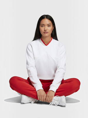 Model wanita mengenakan sweatshirt putih FTFO || BIG BRAND LOW PRICE dengan aksen kerah merah dan celana merah